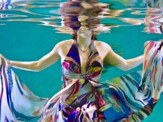 Bruce Christianson, "Underwater Fashion shoot testing with Sophie in a brightly colored flowing dress swirling with reflections on the under-surface of the pool," photograph, Unsplash.